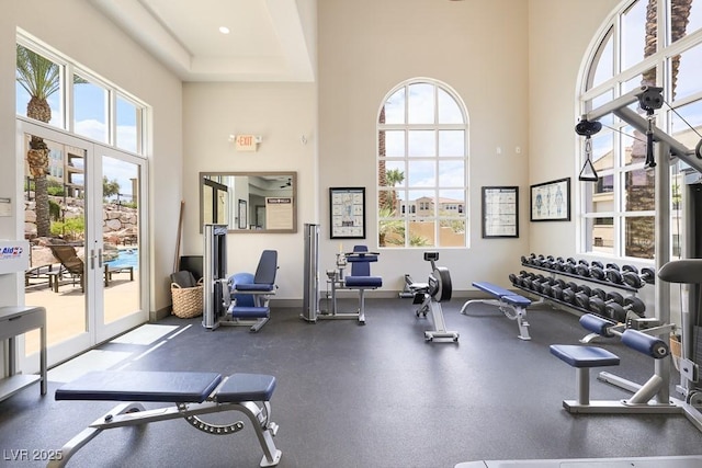 exercise room with a towering ceiling and french doors