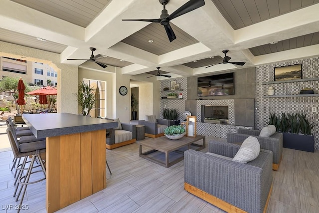 living room with beamed ceiling, a fireplace, and built in features