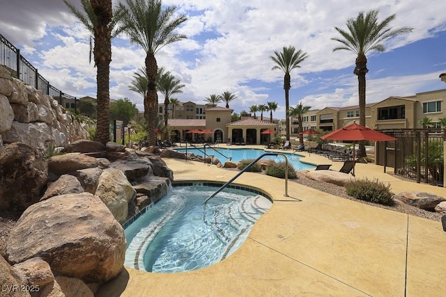 view of swimming pool featuring pool water feature and a patio area