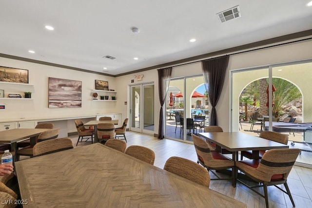 dining room featuring plenty of natural light, ornamental molding, and french doors