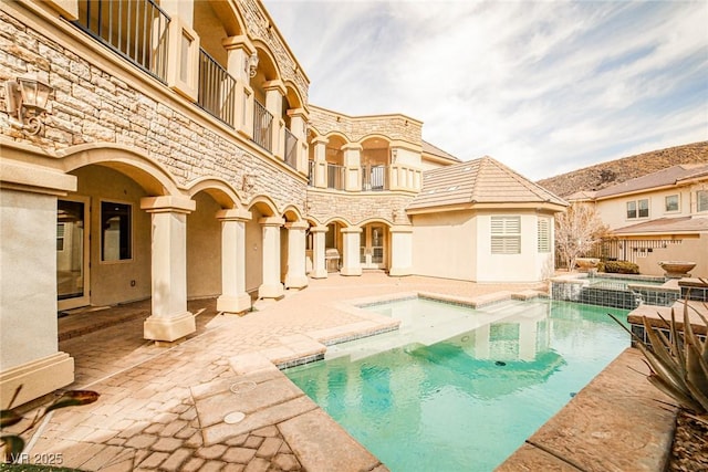 view of swimming pool with a patio and an in ground hot tub