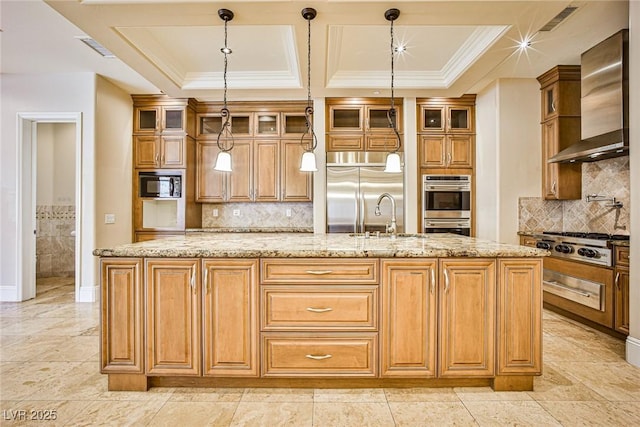 kitchen featuring pendant lighting, wall chimney range hood, a kitchen island with sink, built in appliances, and light stone countertops