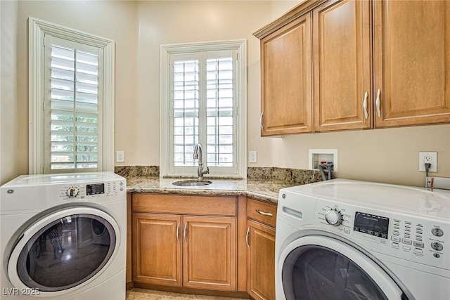 laundry room with cabinets, washing machine and dryer, and sink