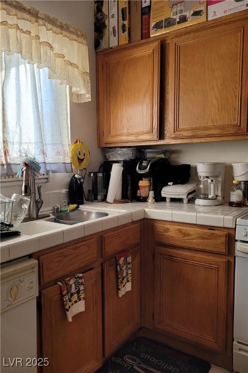 kitchen featuring sink, tile counters, and white appliances