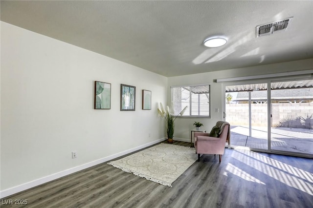 sitting room featuring a textured ceiling and dark hardwood / wood-style flooring