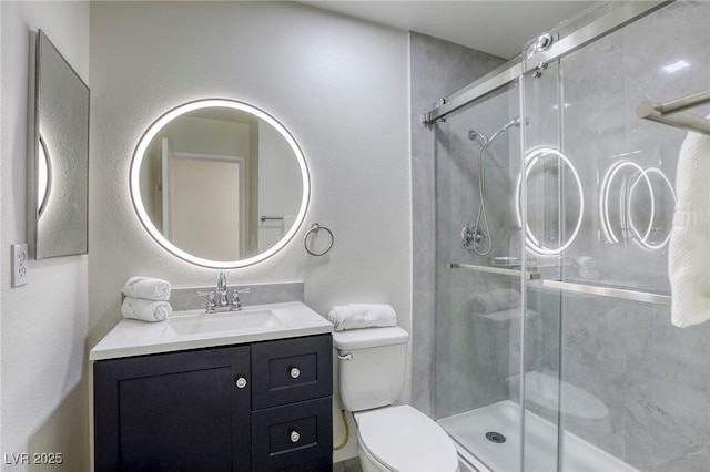 bathroom featuring vanity, an enclosed shower, and toilet