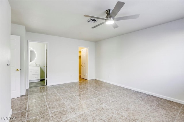 unfurnished bedroom with ceiling fan, a spacious closet, ensuite bath, and a closet