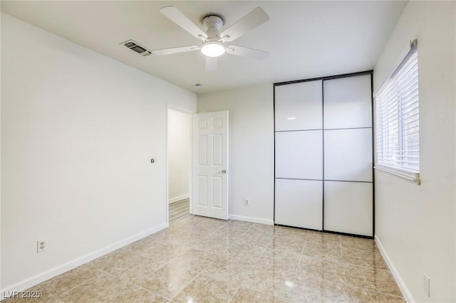 unfurnished bedroom with ceiling fan and a closet