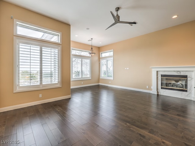 3 Pine Hollow Dr, Henderson, NV 89052 - unfurnished living room featuring a premium fireplace, a ceiling fan, dark wood-style flooring, recessed lighting, and a chandelier