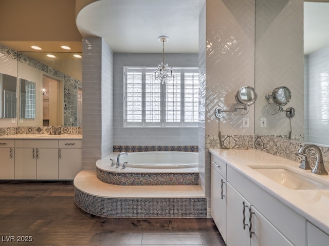 3 Pine Hollow Dr, Henderson, NV 89052 - bathroom featuring a garden tub, two vanities, a chandelier, and tile walls
