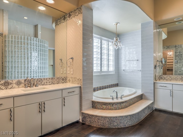 3 Pine Hollow Dr, Henderson, NV 89052 - full bath featuring wood-type flooring, two vanities, a garden tub, and a chandelier