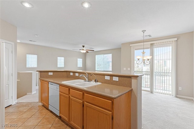 kitchen featuring sink, light carpet, hanging light fixtures, dishwasher, and an island with sink