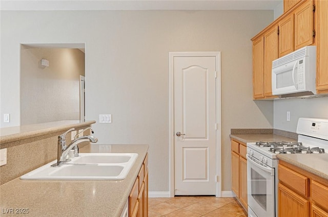 kitchen with light tile patterned flooring, white appliances, and sink