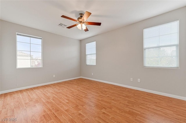 unfurnished room with ceiling fan, a healthy amount of sunlight, and light wood-type flooring