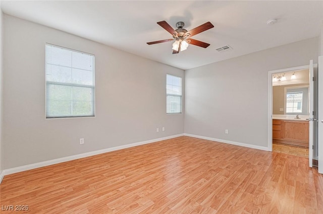 spare room featuring ceiling fan, a healthy amount of sunlight, and light wood-type flooring