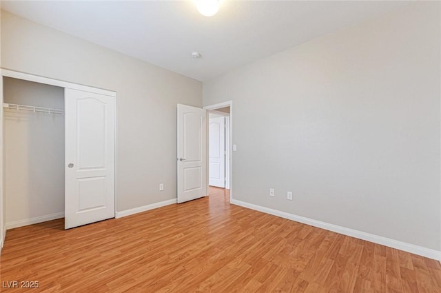 unfurnished bedroom with light wood-type flooring and a closet