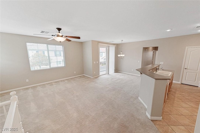 unfurnished room with ceiling fan with notable chandelier, sink, and light carpet