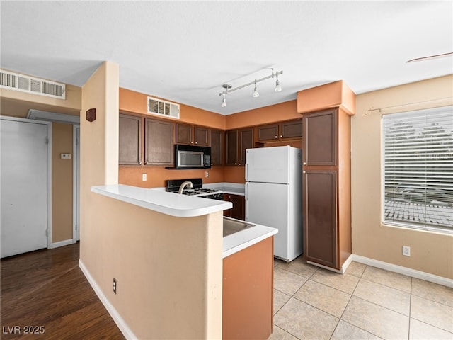 kitchen featuring visible vents, light countertops, and freestanding refrigerator