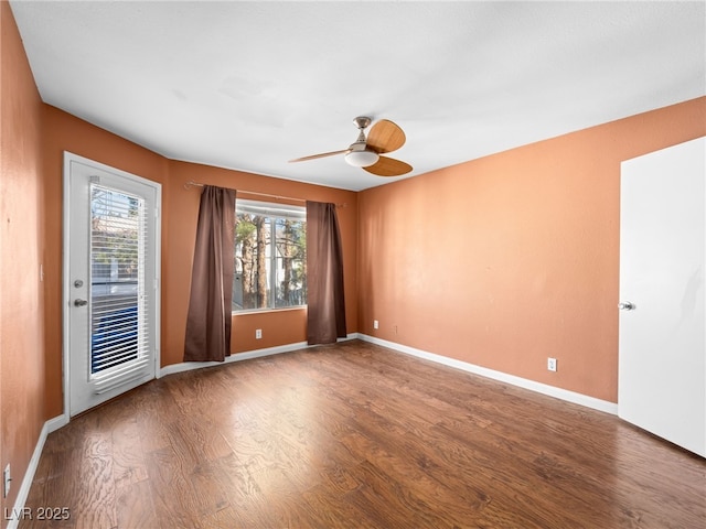 spare room featuring ceiling fan, baseboards, and wood finished floors