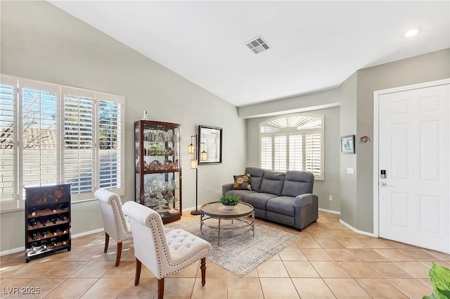 living room with light tile patterned floors and vaulted ceiling