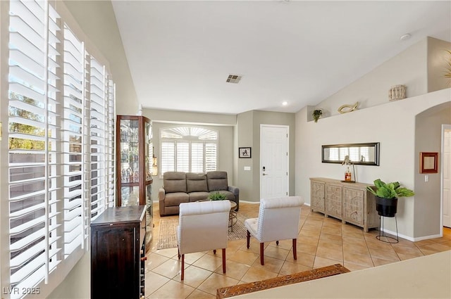 living room featuring lofted ceiling and light tile patterned floors