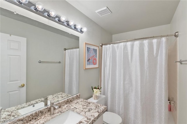 bathroom with walk in shower, vanity, and toilet