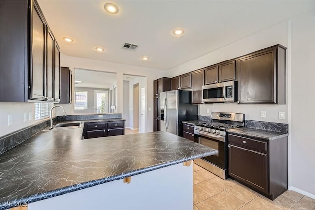 kitchen with stainless steel appliances, sink, a breakfast bar area, and kitchen peninsula