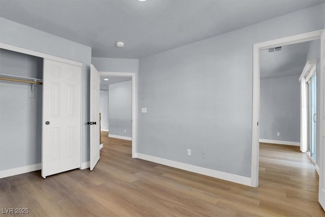 unfurnished bedroom with a closet and light hardwood / wood-style flooring