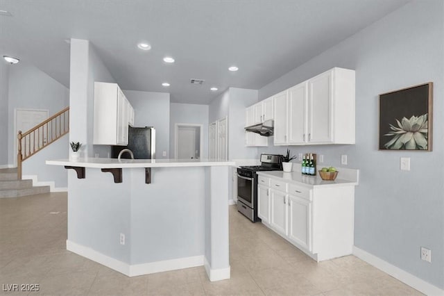 kitchen featuring stainless steel appliances, light tile patterned flooring, a breakfast bar, and white cabinets