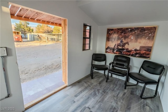 living area with vaulted ceiling and hardwood / wood-style floors