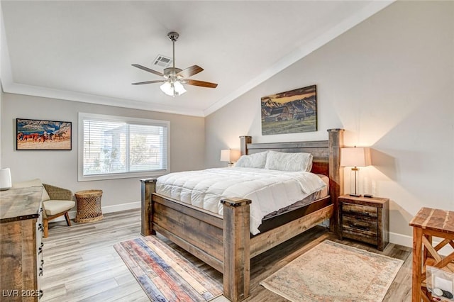 bedroom with vaulted ceiling, ornamental molding, ceiling fan, and light wood-type flooring