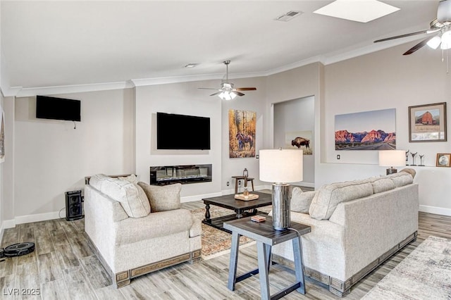 living room with lofted ceiling, hardwood / wood-style floors, crown molding, and ceiling fan