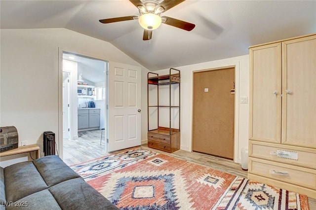 interior space featuring ceiling fan, lofted ceiling, and light hardwood / wood-style floors