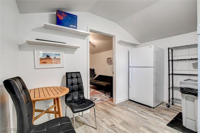 interior space featuring an AC wall unit, lofted ceiling, and light wood-type flooring