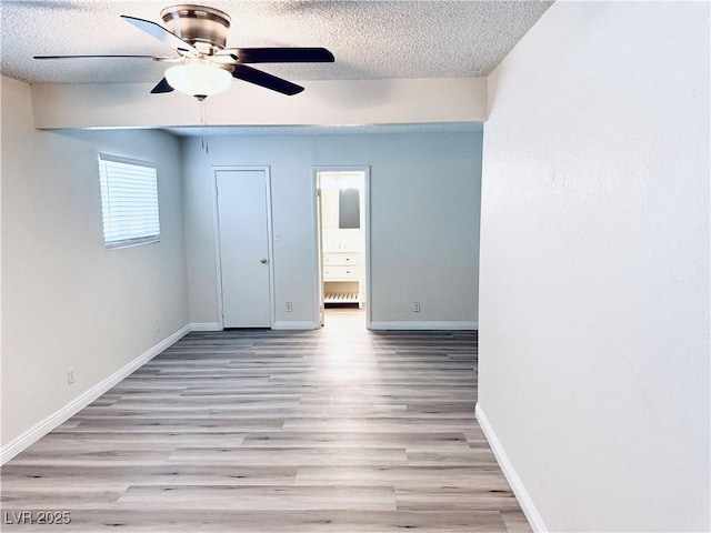 unfurnished bedroom featuring ceiling fan, ensuite bath, a textured ceiling, and light wood-type flooring