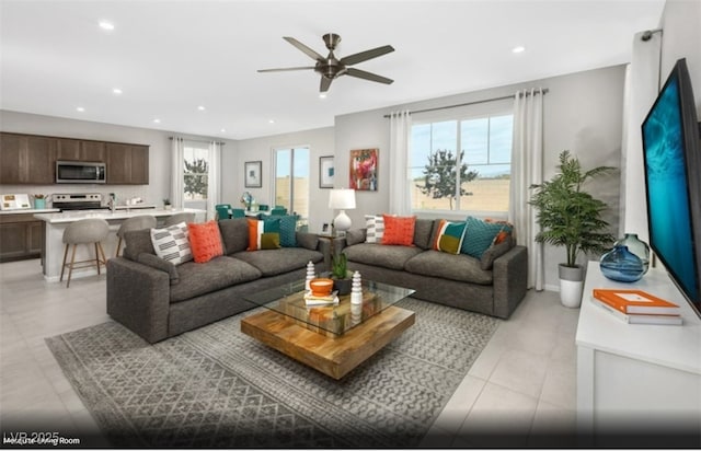 tiled living room featuring ceiling fan and plenty of natural light