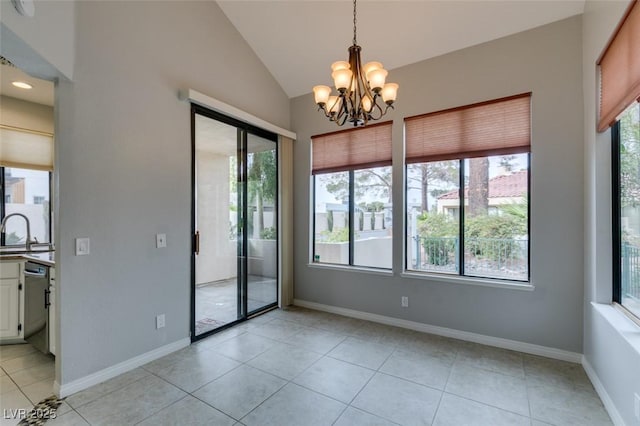 tiled spare room featuring an inviting chandelier, lofted ceiling, and sink