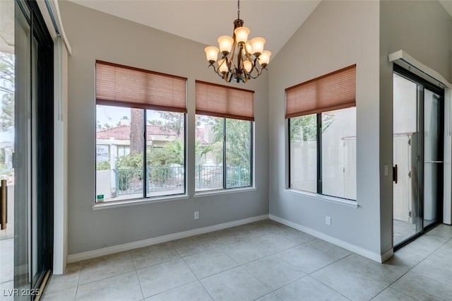 tiled spare room featuring an inviting chandelier and vaulted ceiling