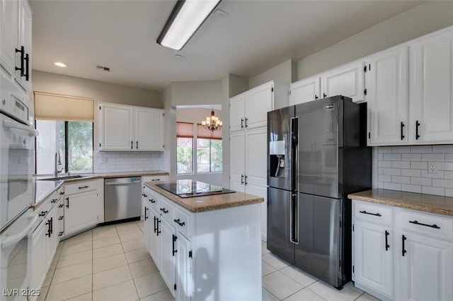 kitchen featuring stainless steel dishwasher, fridge with ice dispenser, and white cabinets