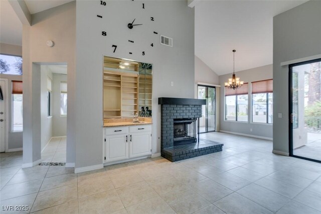 unfurnished living room featuring light tile patterned floors, plenty of natural light, a brick fireplace, and a high ceiling