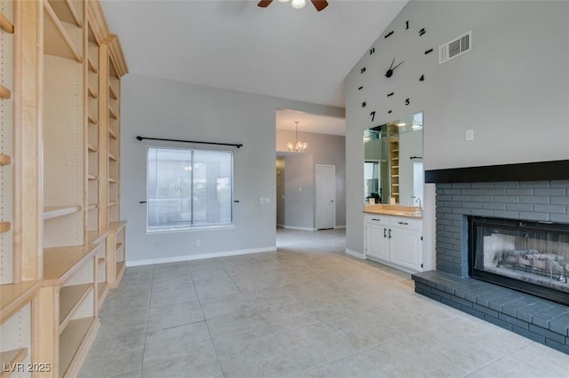 unfurnished living room featuring ceiling fan with notable chandelier, a fireplace, high vaulted ceiling, and light tile patterned floors