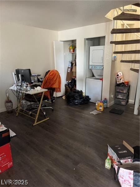 office area featuring stacked washer and dryer and dark wood-type flooring