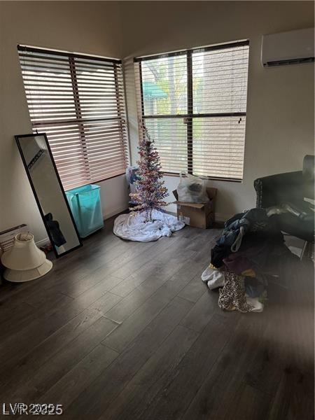 unfurnished dining area featuring a wall mounted air conditioner and dark hardwood / wood-style floors