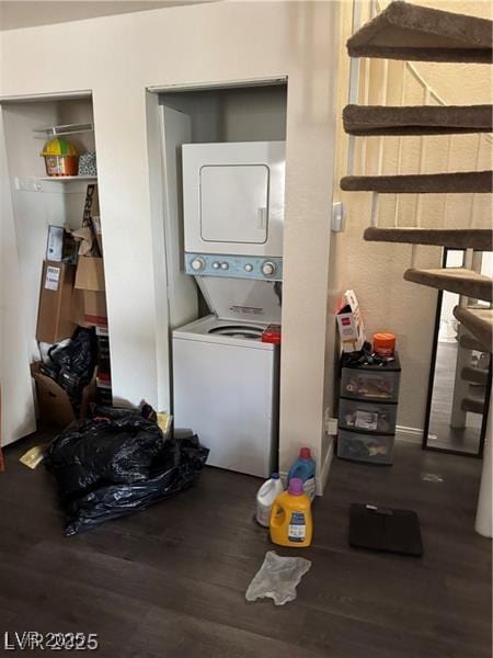 laundry room with stacked washer / drying machine and dark hardwood / wood-style flooring