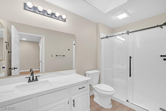 full bathroom featuring vanity, a stall shower, wood finished floors, and toilet