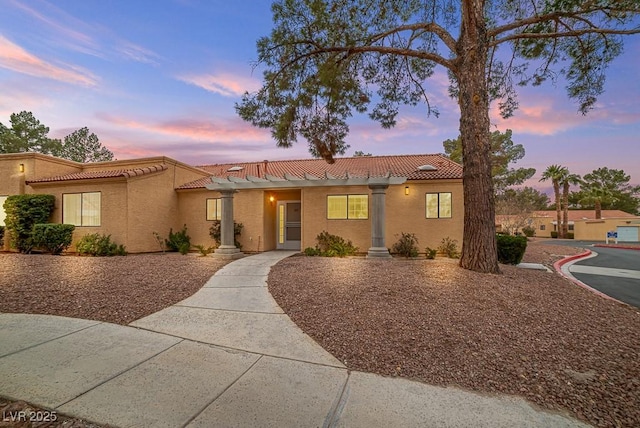 view of front of house with a tile roof and stucco siding