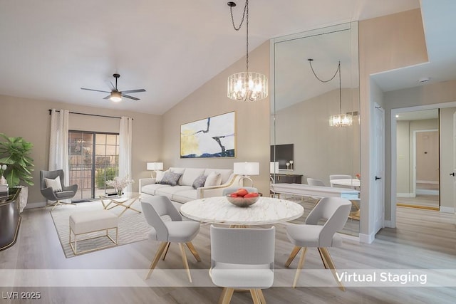 dining space featuring ceiling fan with notable chandelier, vaulted ceiling, and light wood-type flooring