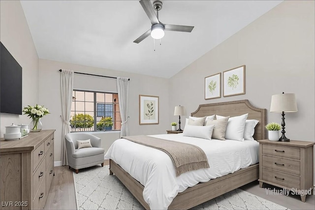 bedroom featuring light wood-style floors, vaulted ceiling, and a ceiling fan