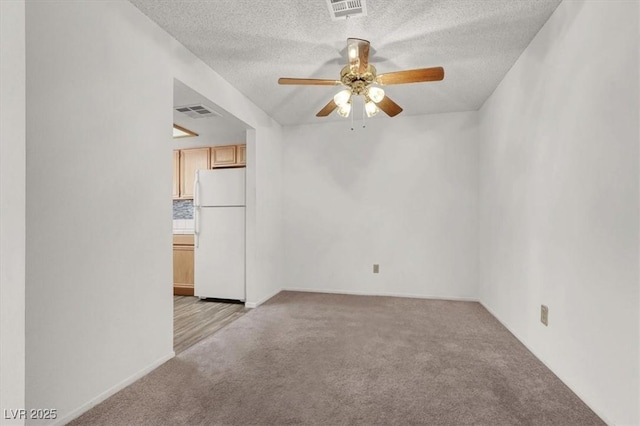 carpeted empty room featuring ceiling fan and a textured ceiling