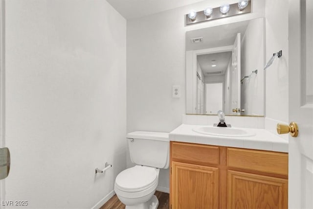 bathroom with vanity, hardwood / wood-style floors, and toilet